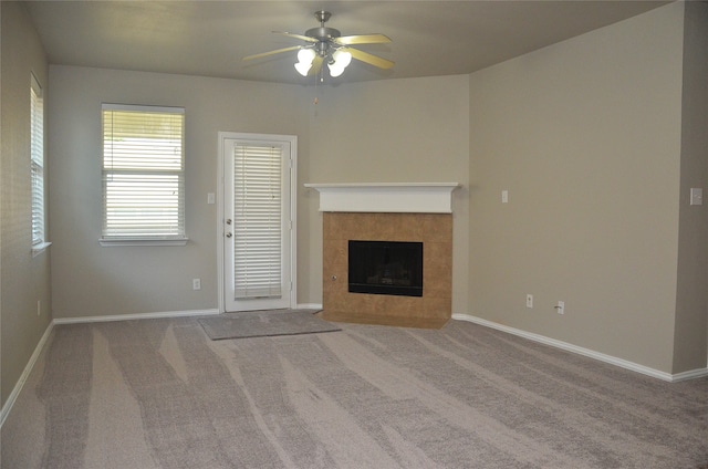 unfurnished living room featuring carpet, ceiling fan, and a tile fireplace