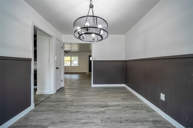 unfurnished dining area with a chandelier and light hardwood / wood-style flooring