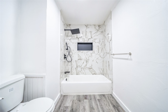 bathroom with tiled shower / bath, wood-type flooring, and toilet