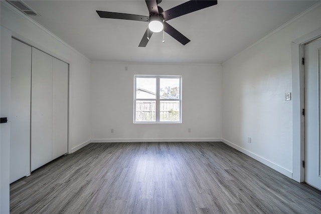 unfurnished bedroom with crown molding, a closet, ceiling fan, and light hardwood / wood-style flooring