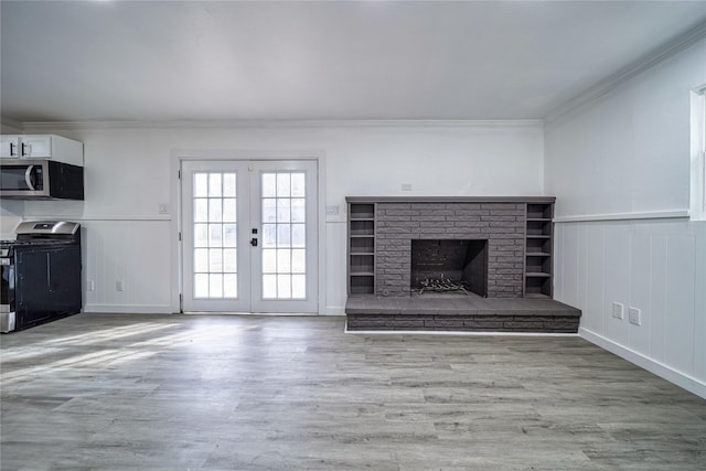 kitchen with sink, crown molding, light hardwood / wood-style flooring, stainless steel appliances, and white cabinets