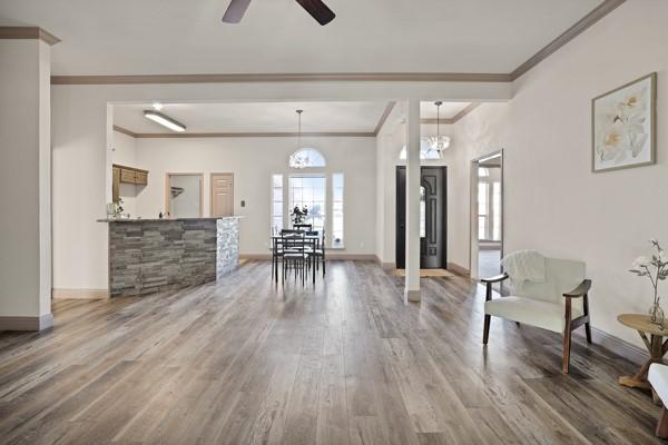 interior space with hardwood / wood-style floors, ornamental molding, and ceiling fan