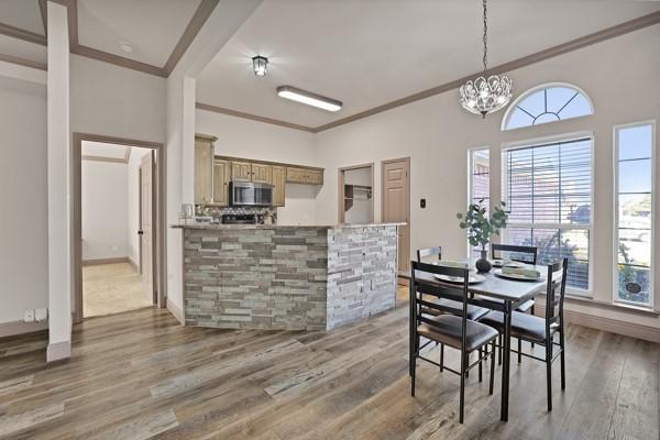 dining room with ornamental molding, plenty of natural light, dark hardwood / wood-style floors, and a chandelier