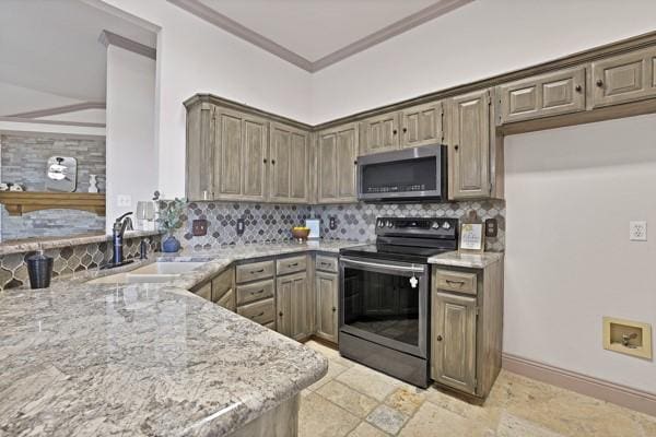 kitchen with tasteful backsplash, stainless steel appliances, light stone countertops, and sink