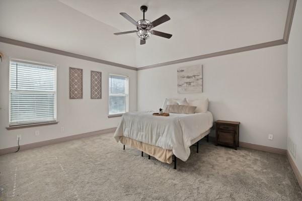 carpeted bedroom with lofted ceiling, ornamental molding, and ceiling fan