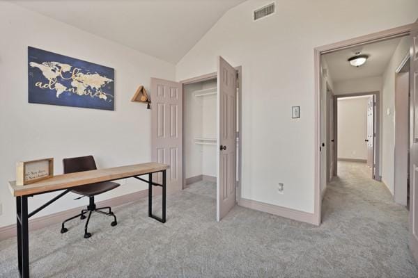 office with lofted ceiling and light colored carpet