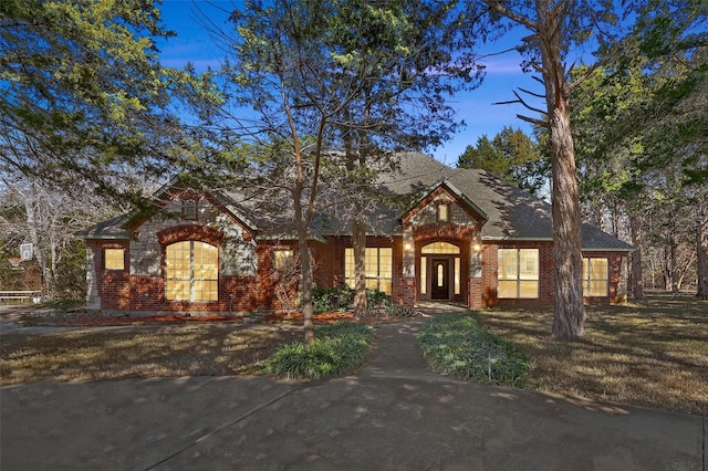 tudor-style house featuring a front yard