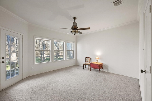 living area with ceiling fan, ornamental molding, and light carpet