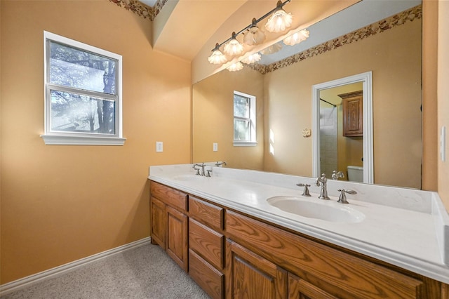 full bath with baseboards, a sink, toilet, and a healthy amount of sunlight