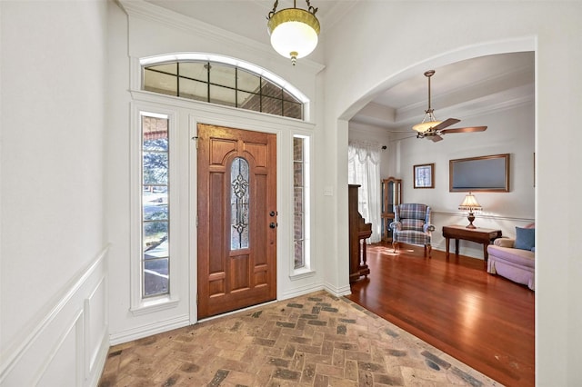 entryway with ceiling fan and ornamental molding