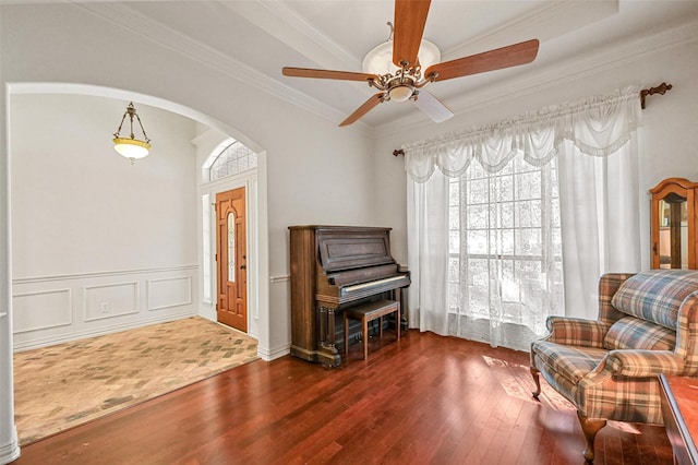 living area featuring hardwood / wood-style floors, ceiling fan, and crown molding