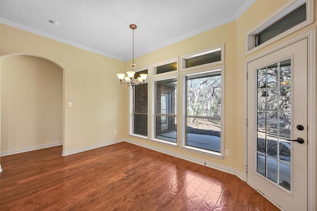 unfurnished dining area featuring ornamental molding, hardwood / wood-style flooring, and a notable chandelier