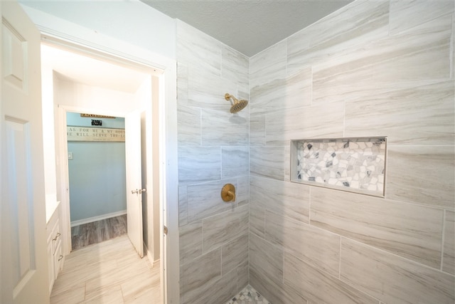 bathroom featuring a tile shower and wood-type flooring