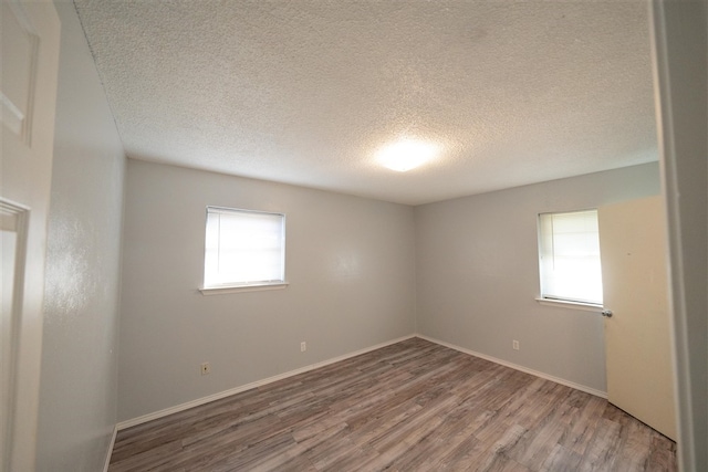 empty room featuring wood-type flooring and a textured ceiling