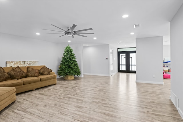 living room featuring ceiling fan, light hardwood / wood-style flooring, and french doors