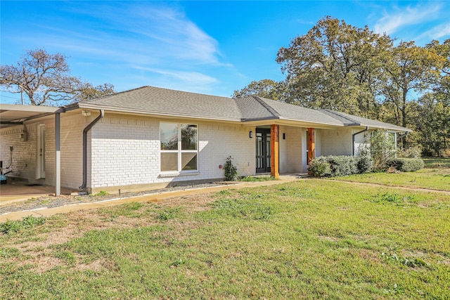 single story home with a front yard, brick siding, and roof with shingles