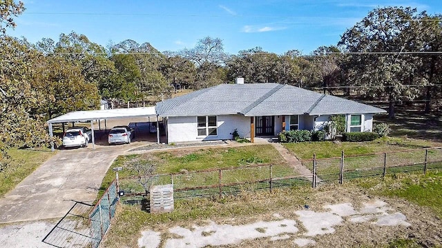 single story home featuring driveway, a shingled roof, a fenced front yard, a front lawn, and a carport