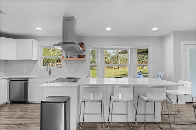 kitchen featuring white cabinets, a healthy amount of sunlight, sink, and island exhaust hood