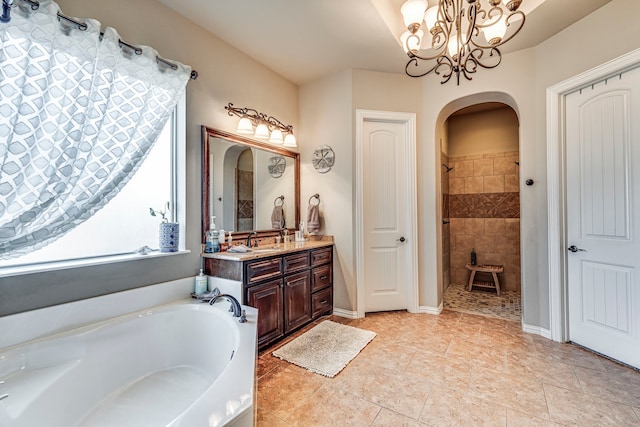 bathroom featuring tile patterned flooring, vanity, shower with separate bathtub, and a chandelier