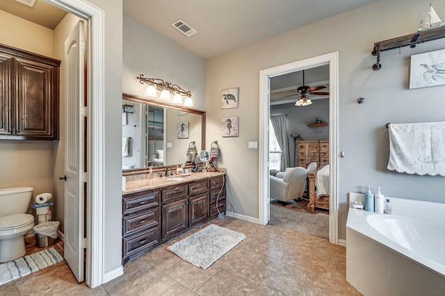 bathroom featuring a bathing tub, ceiling fan, tile patterned flooring, toilet, and vanity