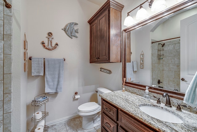 bathroom featuring tiled shower, vanity, toilet, and tile patterned flooring