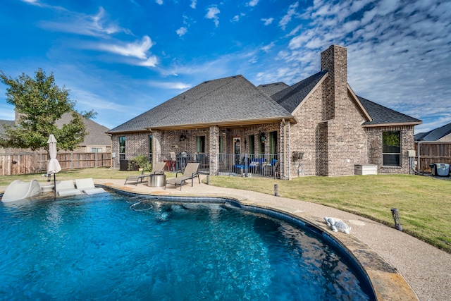 view of swimming pool featuring a lawn, pool water feature, and a patio