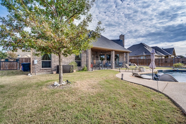 rear view of property with a lawn and a patio area