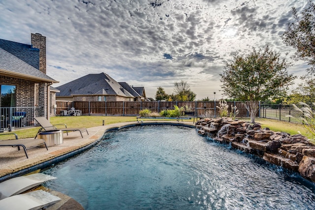 view of pool featuring pool water feature and a yard