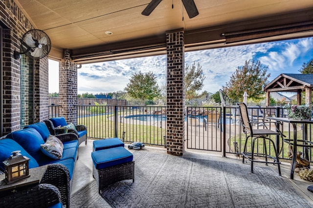 view of patio / terrace with outdoor lounge area, ceiling fan, and a swimming pool