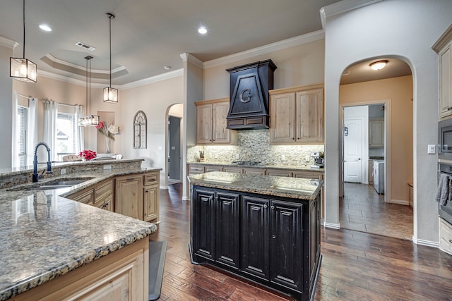 kitchen featuring dark hardwood / wood-style flooring, ornamental molding, sink, pendant lighting, and a kitchen island