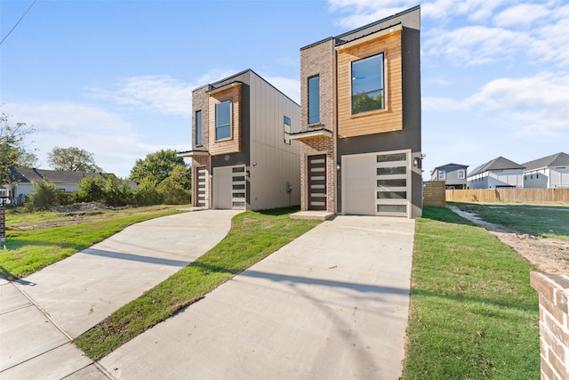 contemporary home featuring a garage and a front lawn