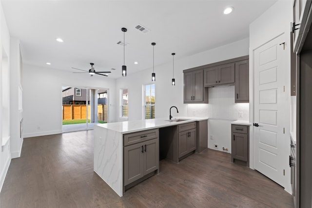 kitchen with kitchen peninsula, dark hardwood / wood-style flooring, ceiling fan, sink, and decorative light fixtures