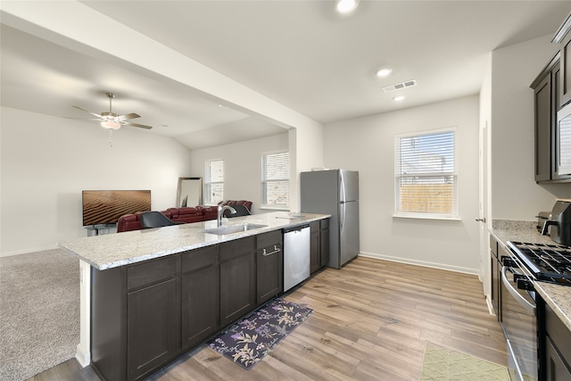 kitchen featuring light hardwood / wood-style floors, light stone countertops, sink, and appliances with stainless steel finishes