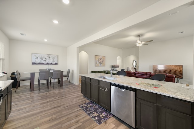 kitchen with sink, stainless steel dishwasher, ceiling fan, light wood-type flooring, and light stone counters