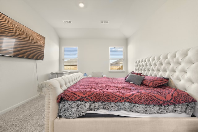 carpeted bedroom featuring lofted ceiling and multiple windows