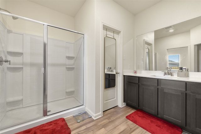 bathroom featuring hardwood / wood-style flooring, vanity, and a shower with shower door