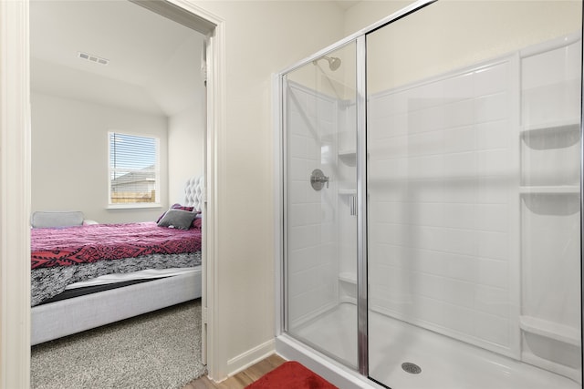 bathroom with hardwood / wood-style floors and an enclosed shower