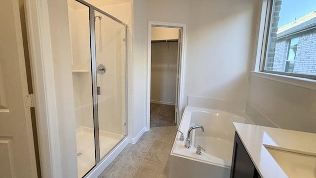 bathroom featuring vanity, independent shower and bath, and a healthy amount of sunlight