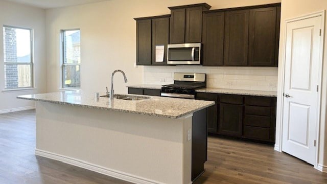 kitchen with dark hardwood / wood-style flooring, sink, backsplash, stainless steel appliances, and dark brown cabinetry