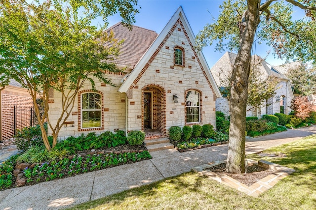 tudor-style house featuring a front yard