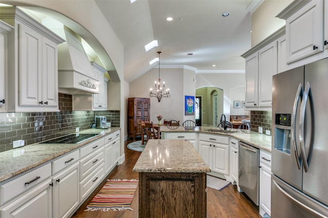 kitchen with dark wood-type flooring, stainless steel appliances, kitchen peninsula, vaulted ceiling, and decorative backsplash