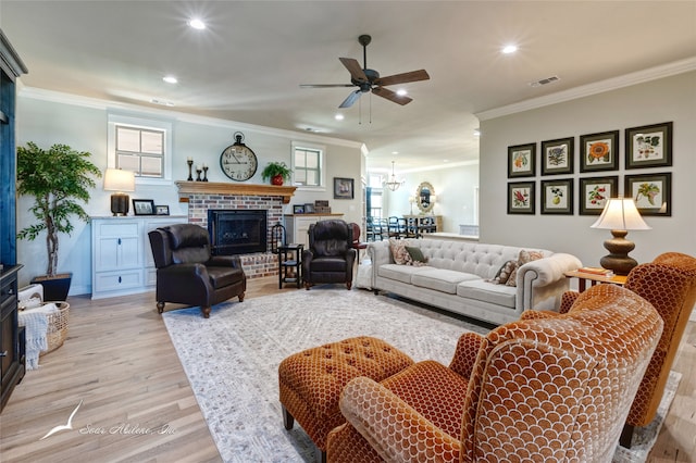 living room with crown molding, light hardwood / wood-style floors, and a brick fireplace