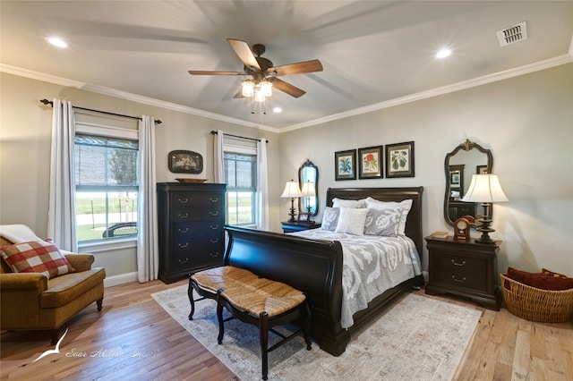 bedroom featuring light wood-type flooring, ceiling fan, and crown molding