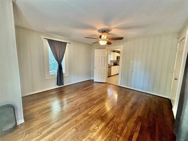 unfurnished living room with ceiling fan and wood-type flooring