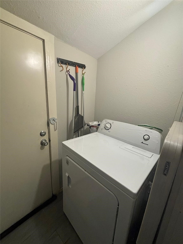 laundry area with washer / dryer and a textured ceiling