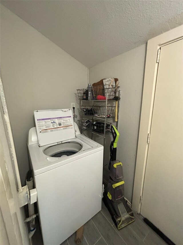 washroom with a textured ceiling and washer / dryer