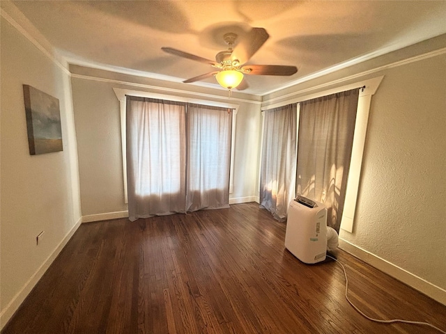 empty room with dark hardwood / wood-style floors, ceiling fan, and crown molding