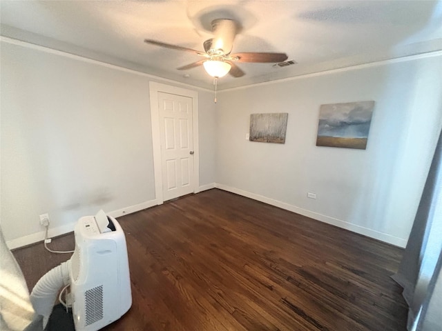 spare room featuring dark hardwood / wood-style flooring, ceiling fan, and crown molding