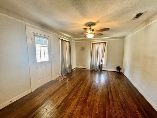 unfurnished room featuring ceiling fan, dark hardwood / wood-style flooring, a textured ceiling, and crown molding