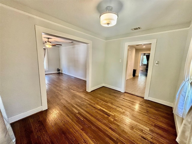 unfurnished dining area featuring crown molding and dark wood-type flooring